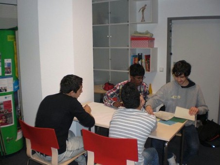 4 Schüler sitzen um einen Tisch und arbeiten