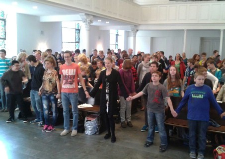Schüler in der Kirche halten sich an den Händen
