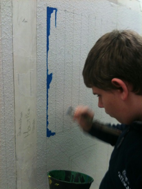 Ein Schüler übt sich als Maler/ Lackierer.
